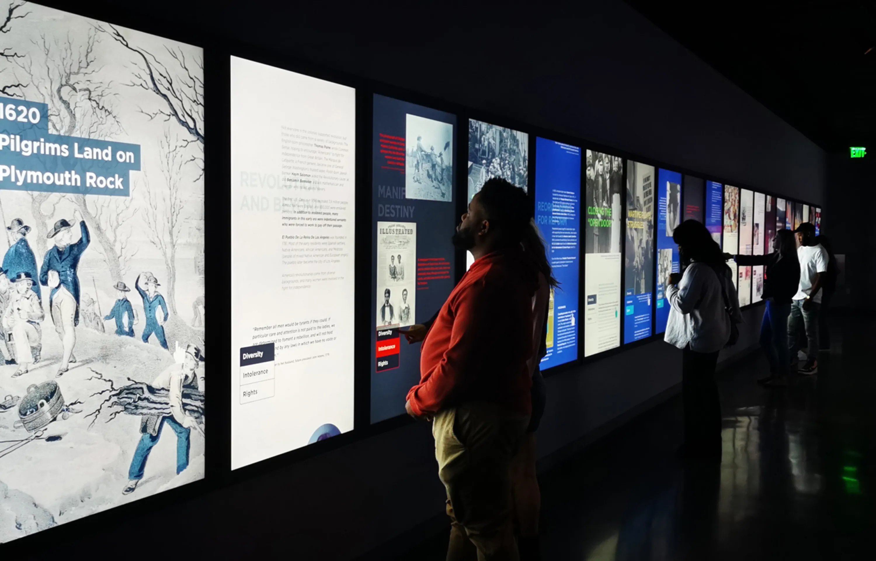 Visitors gather to read interactive text on the We the People screens.