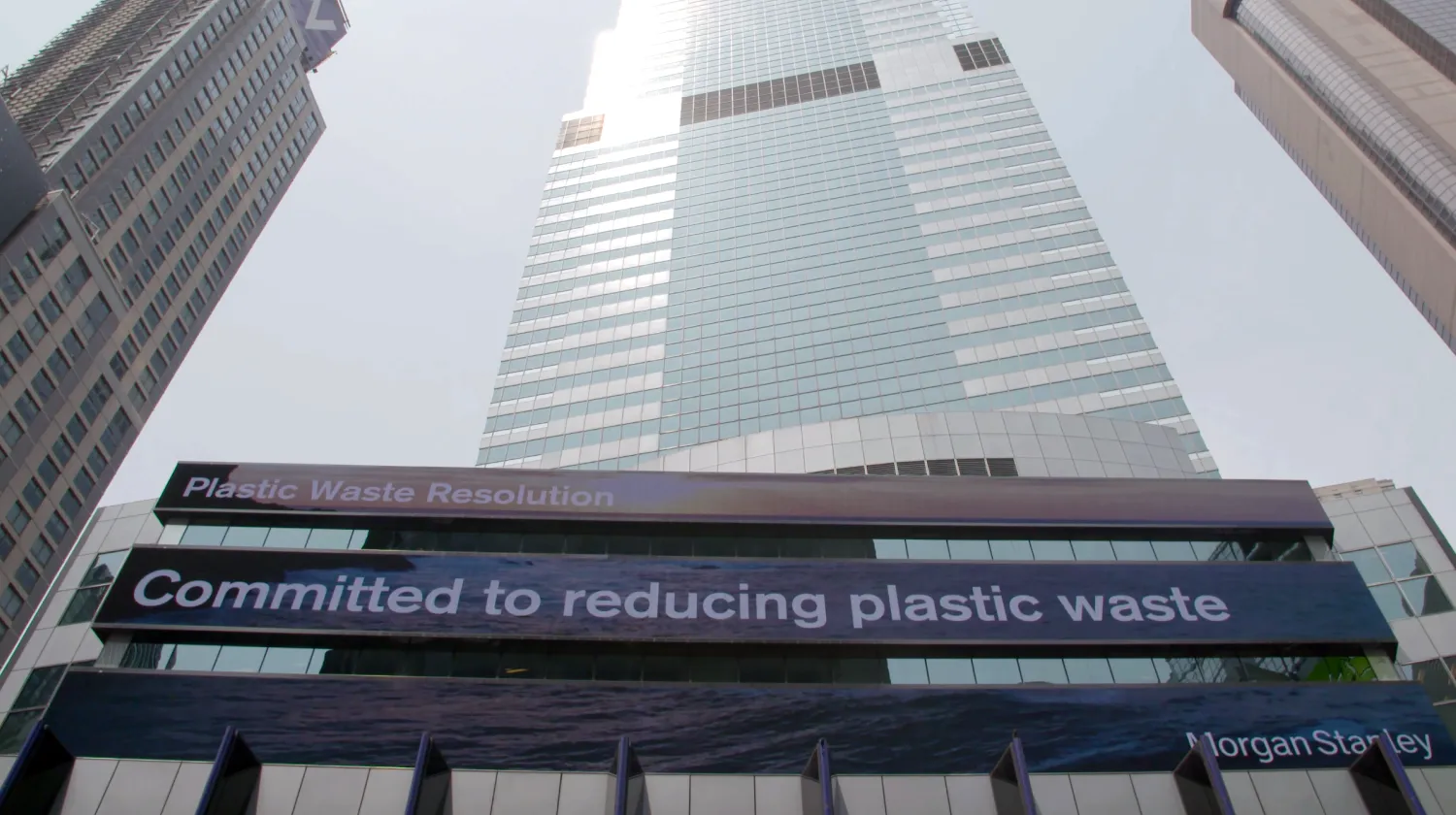 Digital signage banners in front of the Morgan Stanley building reads "Plastic Waste Resolution" and "Committed to reducing plastic waste."