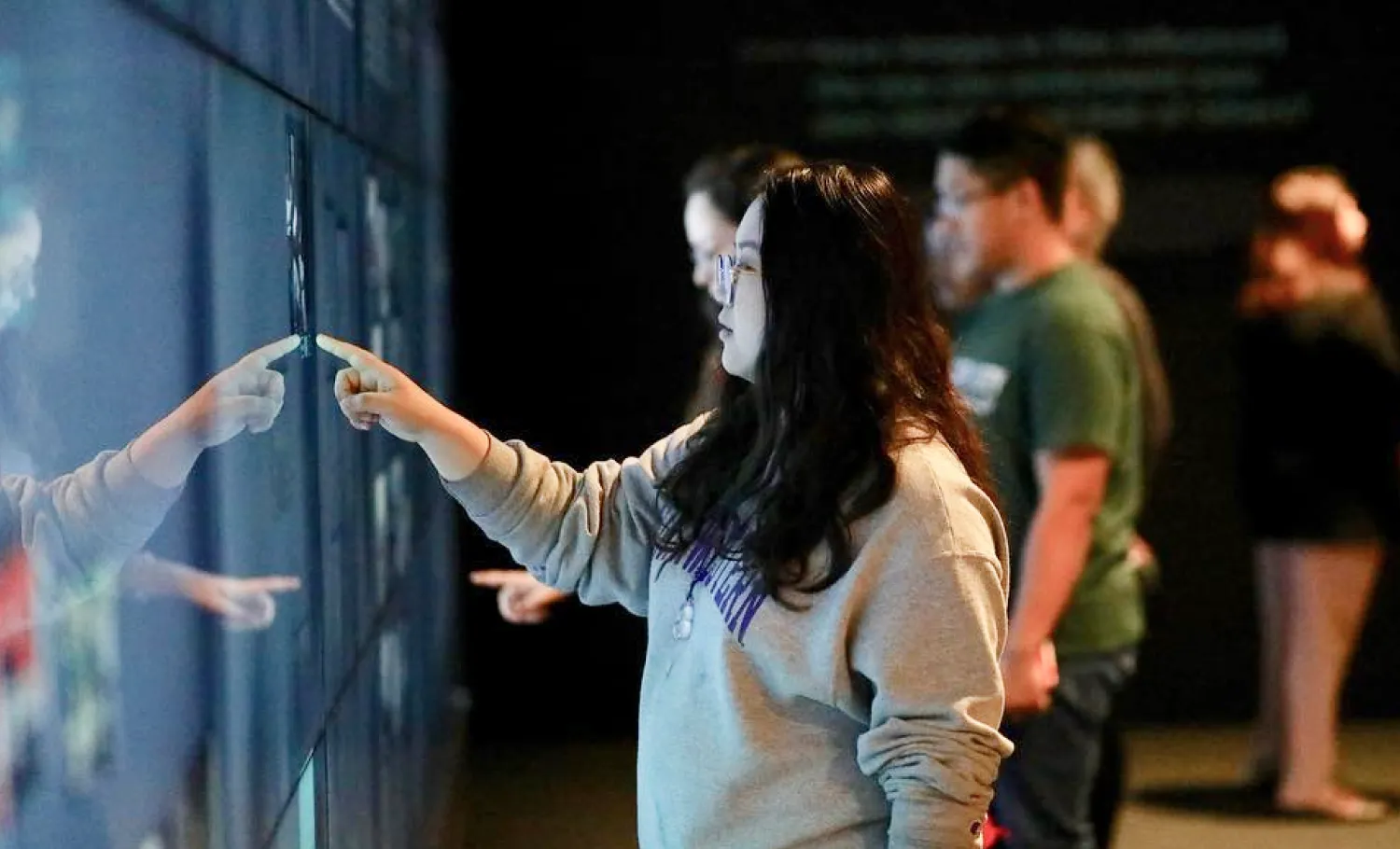Visitors use the interactive screens to view available content.