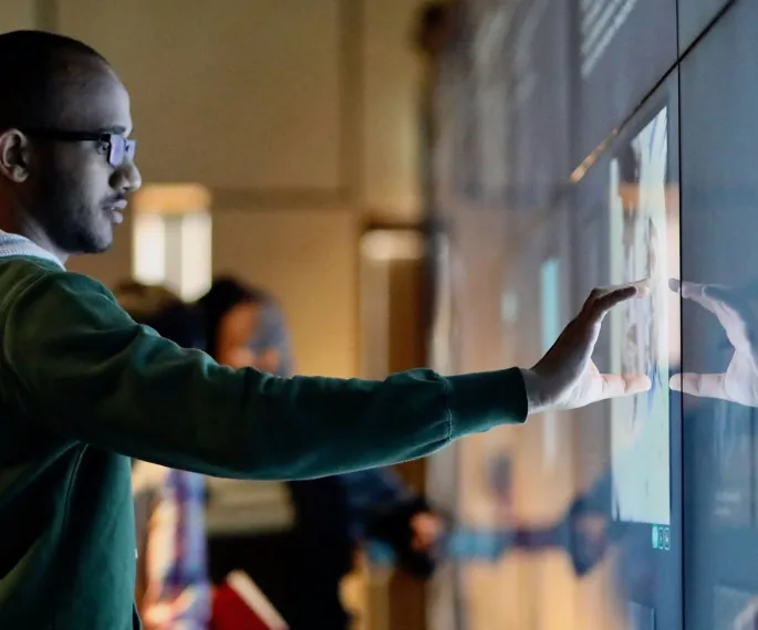 Visitor zooms into an image on the interactive digital wall.