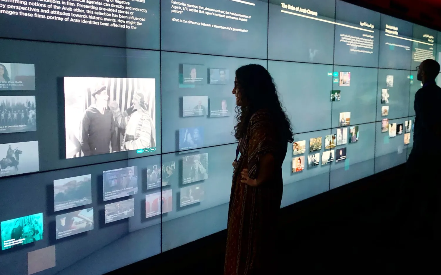 Visitors view the digital wall depicting the history of Arab cinema through different eras.