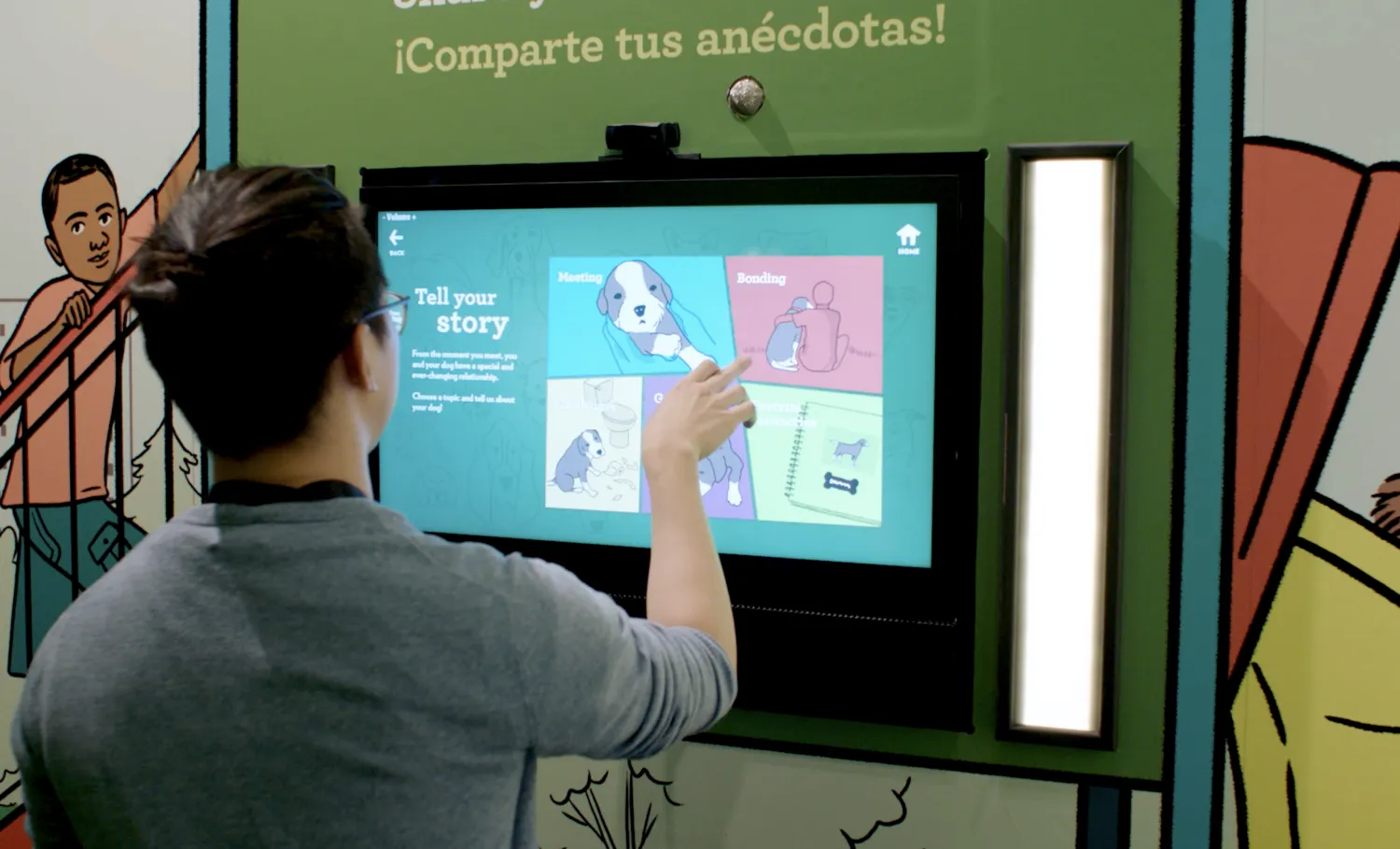Visitor interacting with a digital screen to share images of their dogs on the exhibition screen.