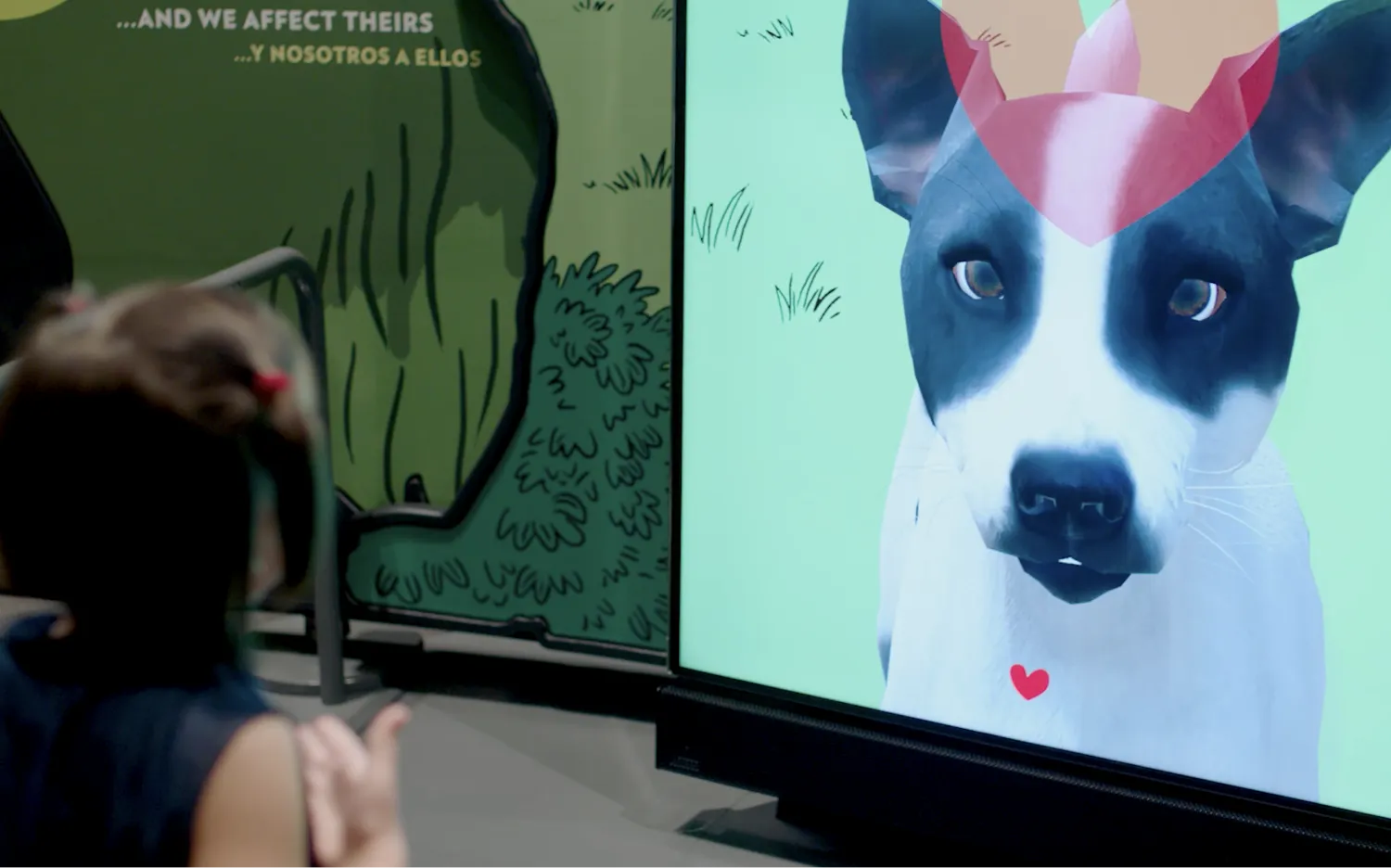 A child standing in front of a vertical digital screen showing an animated dog.