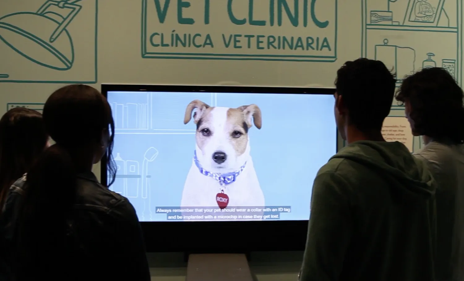 Visitors watch a video on vet clinic and dog care.