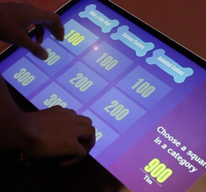 Visitor playing with a "Jeopardy"-esque interactive game with dog related questions.