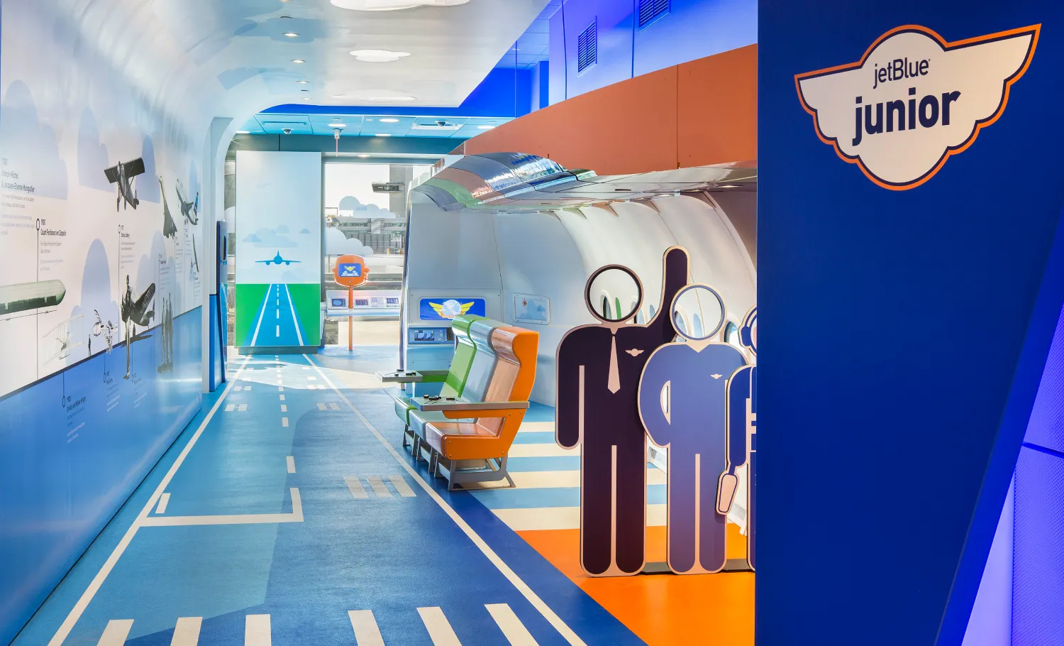 Entrance of JetBlue Junior PlaySpace with standee cutout of stick figures wearing pilot and flight attendants' uniforms.