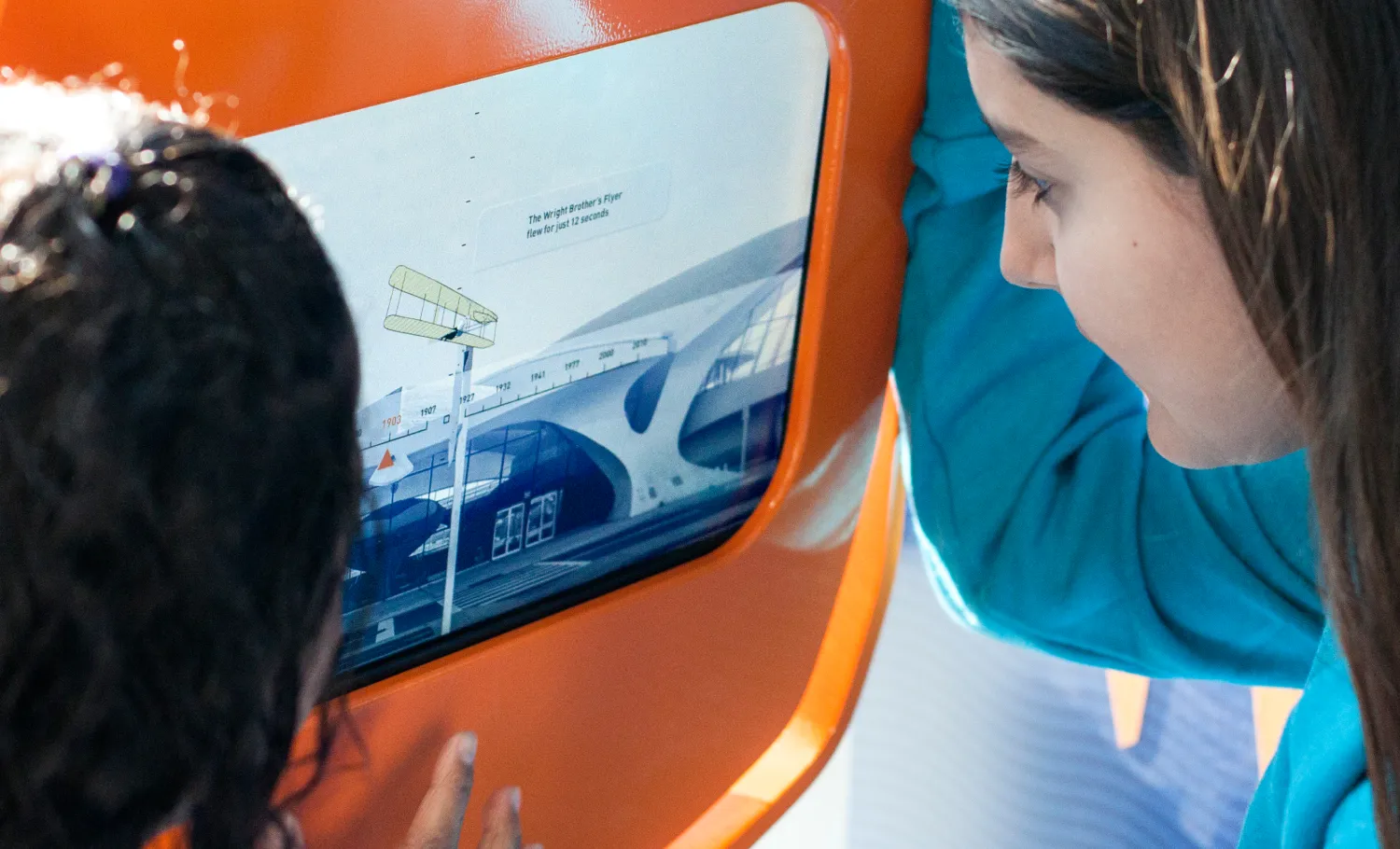 Children and their guardians interacting with different activities provided at the JetBlue PlaySpace.