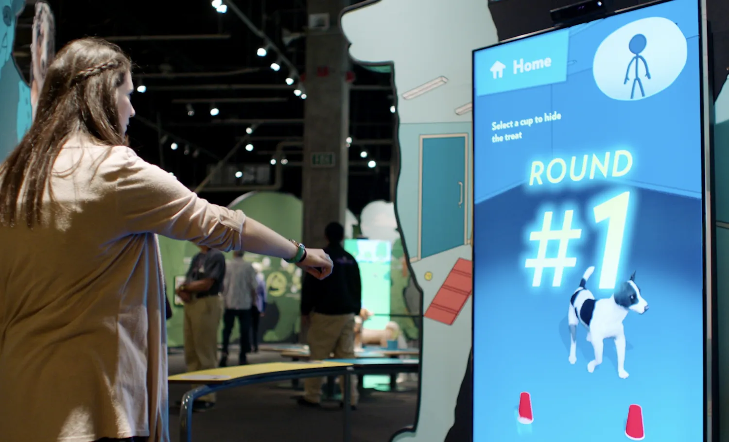 Woman playing with a pet training related gesture-based interactive.