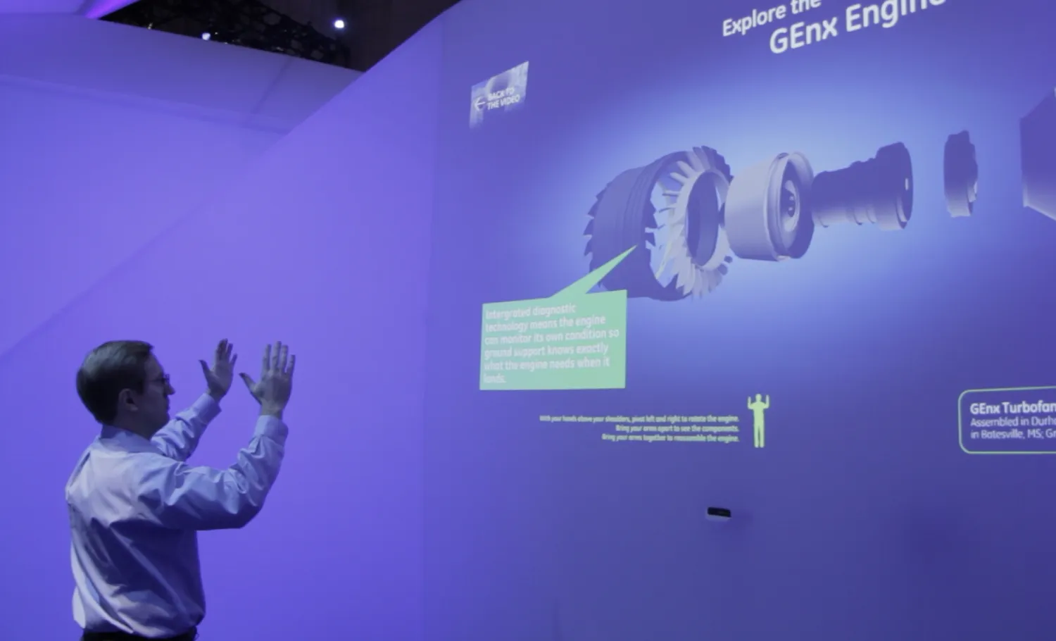 A man interacts with a gesture-based media wall.