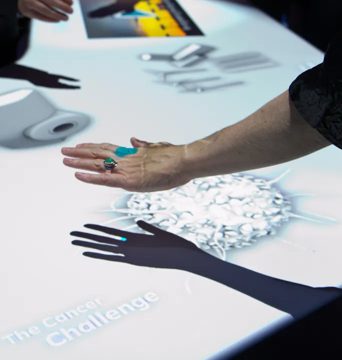Visitor's hand hovering over a motion-sensored activity table.