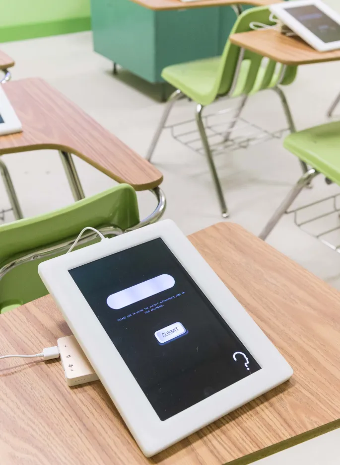 Digital tablets placed on classroom tables.