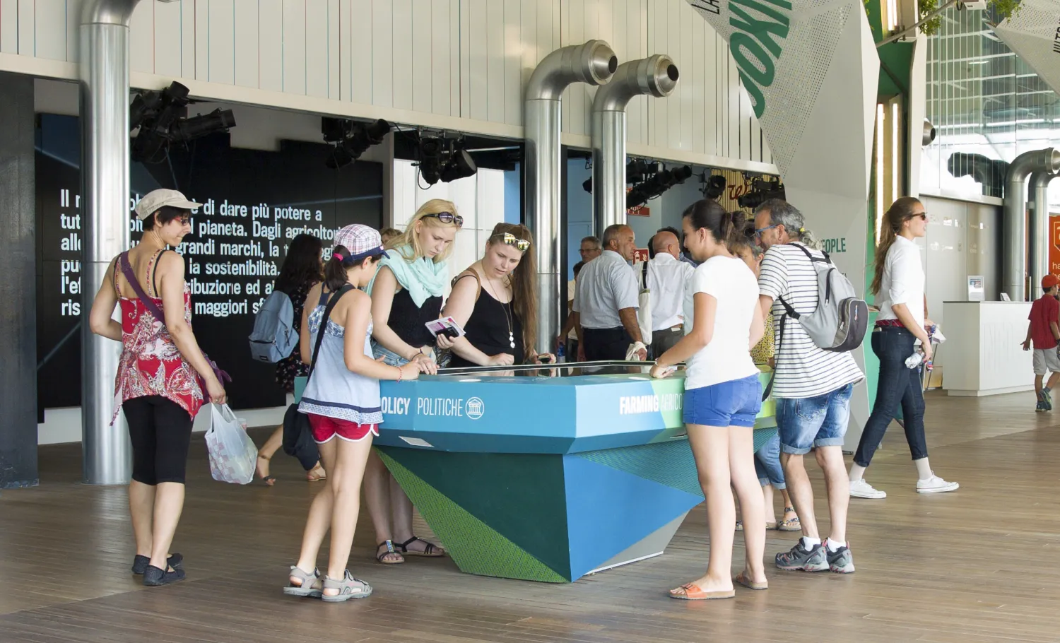 Visitors surround and interact with a digital activity table.