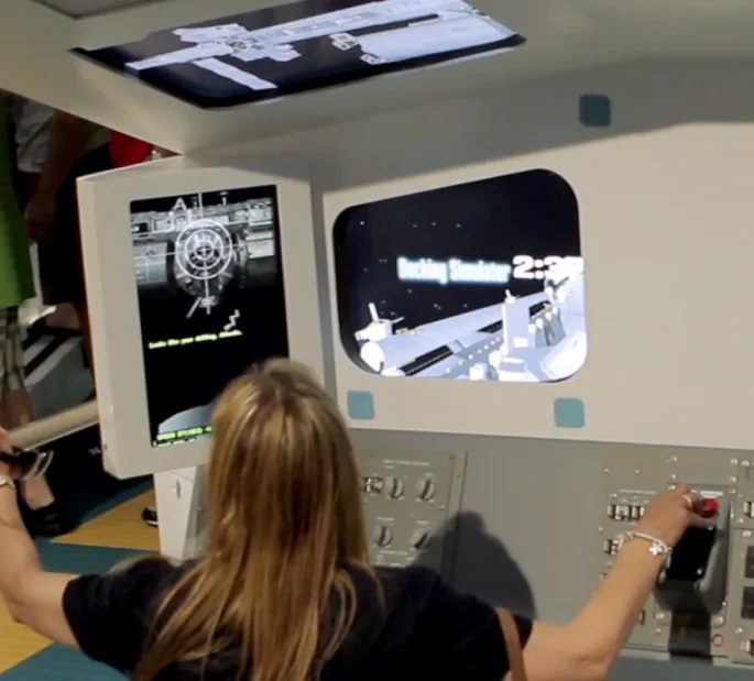 A woman plays on the Docking Simulator interactive